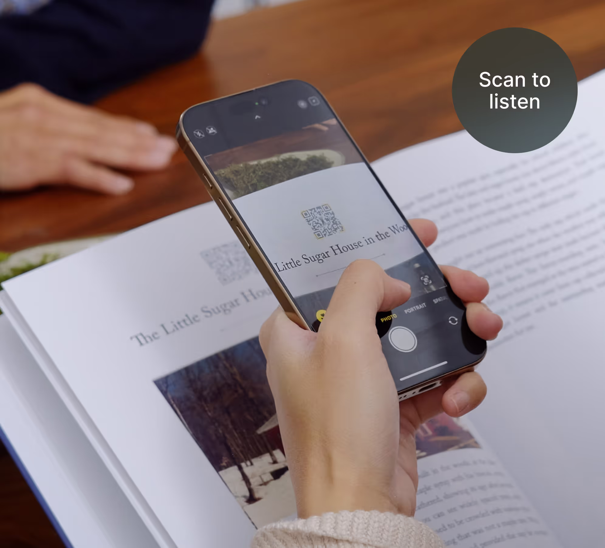 A photo of someone scanning the QR code from an opened Remento book